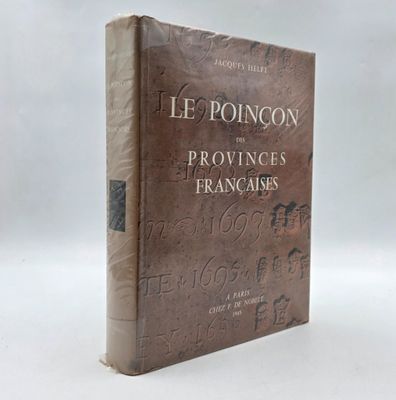 un vieux livre posé sur une table blanche à côté d'un mur blanc