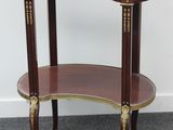 une petite table avec un plateau en marbre, posée sur un sol recouvert de moquette