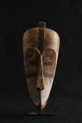 gros plan d'un masque en bois sur fond noir
