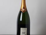 a bottle of champagne sitting on a table next to a bottle of wine