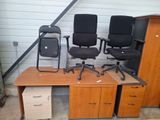 three chairs and a desk in a garage