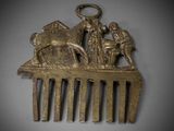 a gold comb with a picture of a man and a woman on it