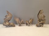 five silver figurines of birds sitting on a table