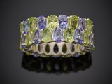 un gros plan d'une bague ornée de pierres vertes et bleues