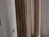 two columns in the corner of a room with wood flooring
