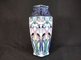 un vase orné d'un motif d'oiseau sur fond noir