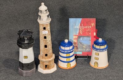 trois petits phares et un livre posé sur une table