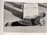 black and white photograph of a woman laying on the ground talking on a cell phone
