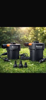 a couple of black and orange water pumps sitting on top of a lush green field