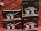 three sets of stainless steel pots and pans on a pink table cloth