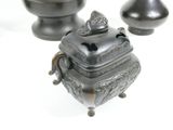 three small metal objects sitting on a white surface