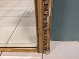 a mirror that is sitting on the floor in front of a wall