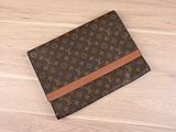 une pochette Louis Vuitton posée sur un parquet
