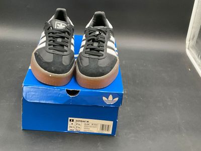 adidas superstar shoes in a blue box on a table