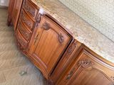 a wooden cabinet with a marble top in a room