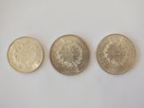 three different types of coins are shown on a white surface