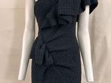 Le mannequin porte une robe noire ornée d'un nœud.