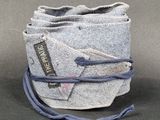 grey felt bag with blue string and a tag on it