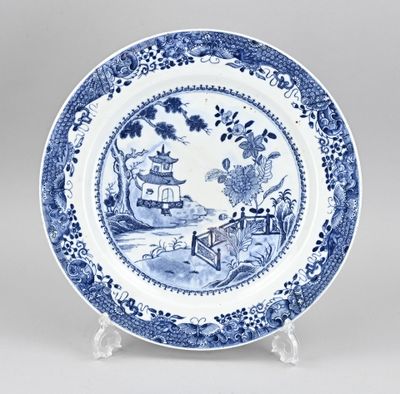 blue and white plate with a landscape scene on it