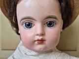 a close up of a doll with a hat on
