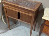 une petite table avec un tiroir, placée à côté d'une chaise