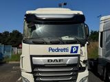 un camion blanc garé sur un parking à côté d'une camionnette