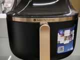une friteuse à air chaud Philips exposée dans un magasin, avec ses étiquettes de prix
