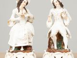 pair of antique porcelain figurines of women sitting on a bench