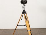 an image of a tripod on a wooden floor with a white wall in the background