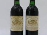 two bottles of red wine sitting next to each other on a table