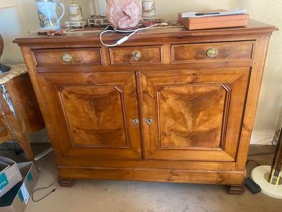 une commode en bois avec des tiroirs, sur laquelle est posée une lampe