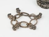 a silver bracelet that has a bunch of charms on it