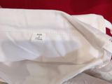 a close up of a white shirt on a red bed