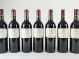 six bouteilles de vin sont alignées sur une surface blanche