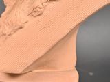 a clay sculpture of a woman ' s head on a pedestal
