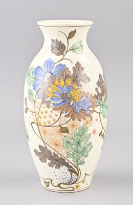un vase blanc orné de fleurs bleues et jaunes