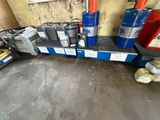 de nombreux bidons d'huile alignés sur une étagère dans un garage