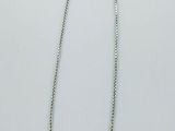 un gros plan d'un collier sur une surface blanche avec un fond blanc