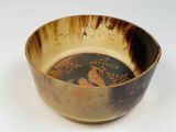 a brown bowl with a bird on it sitting on a table
