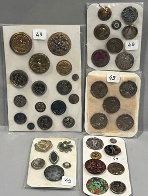 Plusieurs types de boutons et d'aimants sont exposés dans une vitrine.