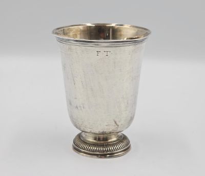 une coupe en argent posée sur un socle, sur fond blanc
