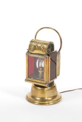 a small brass lantern with a red light on it