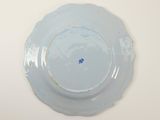 a plate with a blue flower on it on a white table