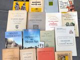 Plusieurs livres sont empilés les uns sur les autres par terre.