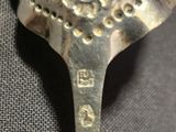 a silver spoon with a bird on it on a table