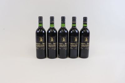 quatre bouteilles de vin sont alignées sur une surface blanche