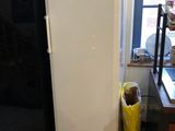 a white refrigerator in a kitchen next to a window