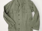 a green jacket is hanging on a white wall