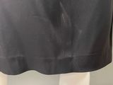 the back of a woman ' s black skirt with a white shirt on it