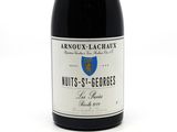 a close up of a bottle of wine on a white surface